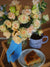 a vase of flowers next to a plate of food
